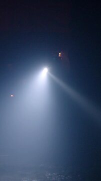 Rescue forces search for survivors inside a dark tunnel using flashlights