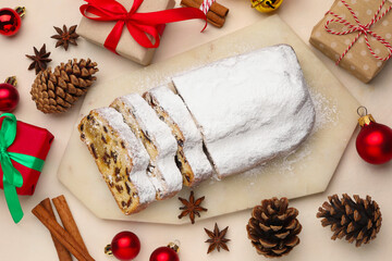 Cut traditional Stollen cake, gifts and Christmas decor on white table, flat lay