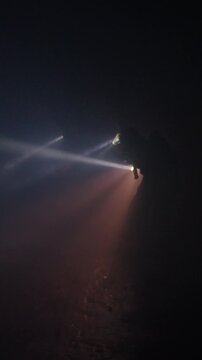 Rescue forces search for survivors inside a dark tunnel using flashlights