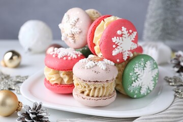 Tasty macarons and Christmas decor on white table, closeup