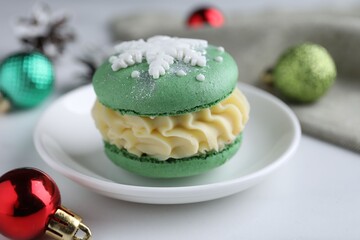 Tasty macaron and Christmas decor on white table, closeup