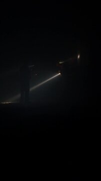 Rescue forces search for survivors inside a dark tunnel using flashlights