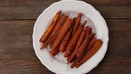 honey roasted baby carrots on white plate top view zoom - Powered by Adobe