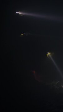 Rescue forces search for survivors inside a dark tunnel using flashlights