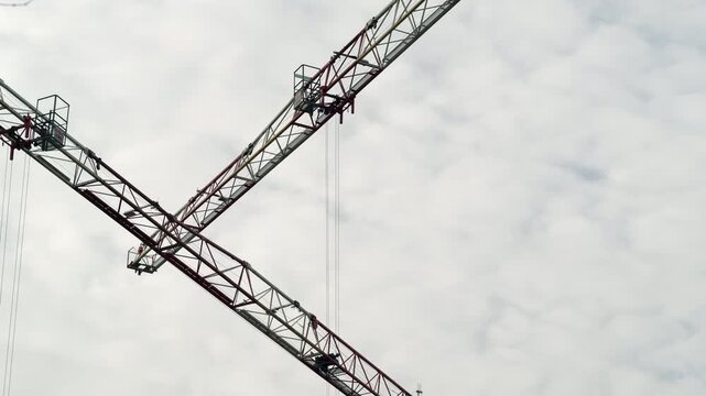 Two Crane booms moving, One leaves Frame
