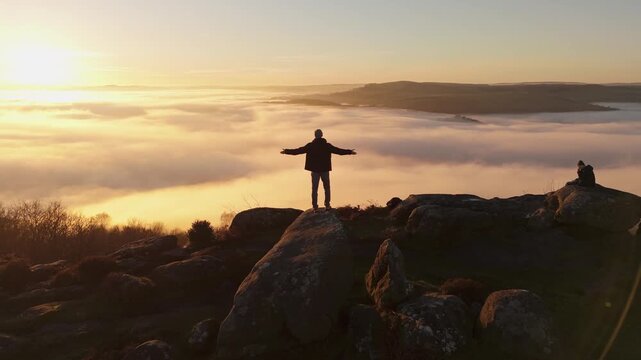 A man demonstrating scenic Cloud Inversion at the Peak District.  Cinematic Drone Landscape Exploration around Froggatt Edge, Curbar Edge and Baslow Edge, which are the most popular hiking trails.