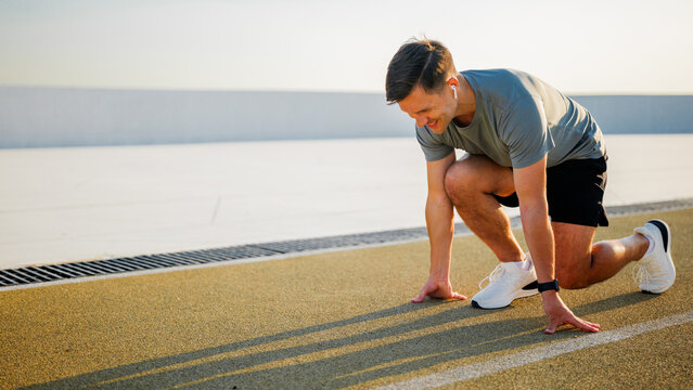 Man preparing to sprint on outdoor track