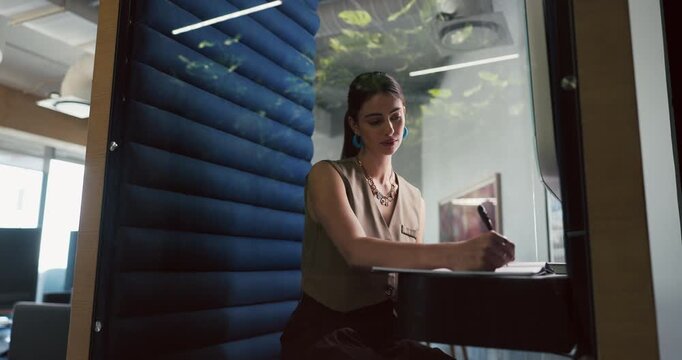 Business, woman and writing in office pod for story planning, editor feedback and creative process. Hybrid work, journalist or notes in cubicle for publication draft, fact checking submission or info