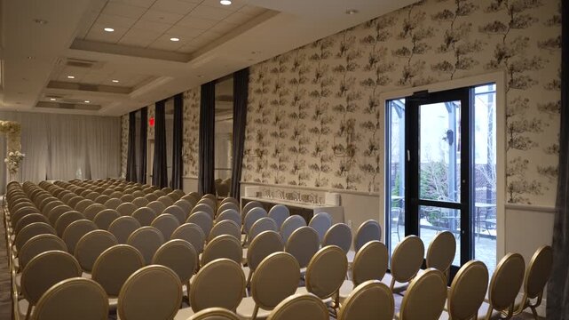 An elegant event hall with rows of gold chairs set for a ceremony. The serene and sophisticated atmosphere is perfect for wedding promotions, venue marketing, or interior design concepts.