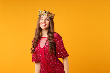 Fototapeta premium Woman wearing luxury crown on orange background