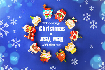 Merry Christmas Happy New Year text surrounded by colorful festive toy train carriages on a snowy blue background.