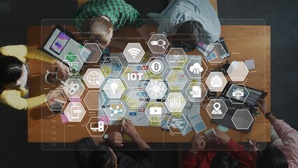 A diverse team engages in collaborative discussions about technology and digital innovation, surrounded by smart devices and visual data representations in a modern workspace. Raster