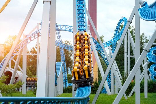 Capturing the thrill, energy, and fun of high-speed theme park adventures. Exciting roller coaster speeding through loops and turns at a vibrant amusement park - Powered by Adobe