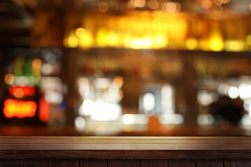 Empty wooden table in bar, blurred background. Space for design