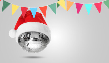 Merry Christmas and Happy New Year. Disco ball with Santa hat and flags on grey background. banner design with space for text
