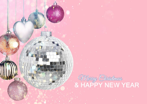 Merry Christmas and Happy New Year card. Shiny disco ball and festive ornaments on pink background, bokeh lights