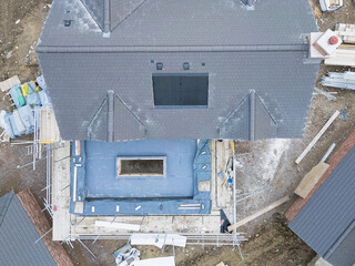 Interesting drone top down view of the construction of a house and a conservatory roof. The hole in the conservatory is for a glass lantern.