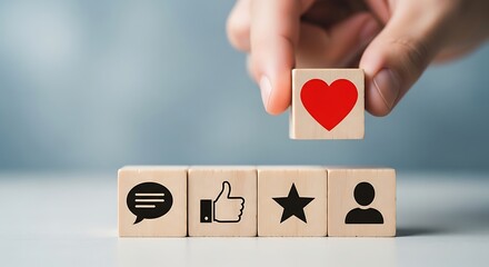 Hand placing a wooden block with a red heart icon on top of other blocks with social media icons