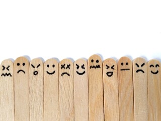 Happy, neutral, and sad emoji on wooden craft stick. mental health awareness concept. Copy space 
