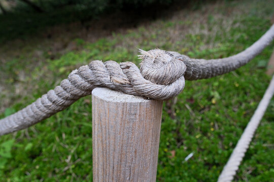 Rope on a wooden pole. Rope tied to a wooden post in the park. Close-up.