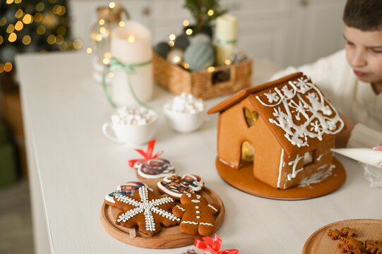A mother and son are preparing a gingerbread house for the Christmas and New Year holidays. - Powered by Adobe