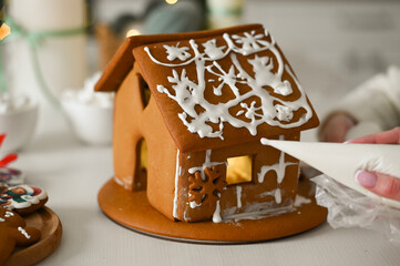 A mother and son are preparing a gingerbread house for the Christmas and New Year holidays.