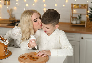 A mother and son are preparing a gingerbread house for the Christmas and New Year holidays.