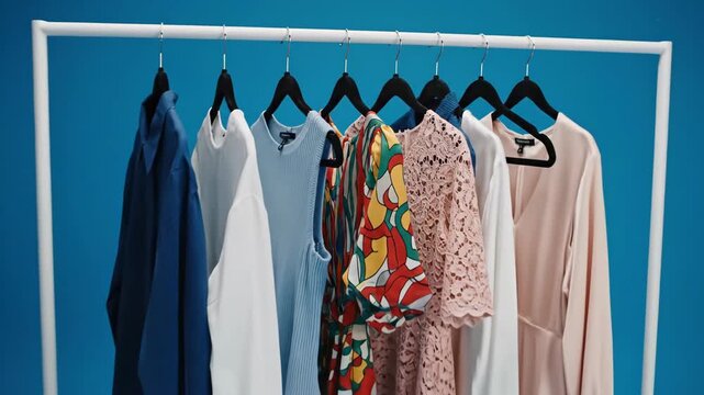 Rack of stylish womens clothing with a variety of colors and textures on hangers against a blue background with snow black friday sale