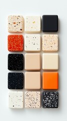 Fototapeta premium A grid of 15 square material samples, showcasing various speckled and solid color finishes, arranged on a white background.