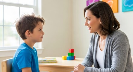 Woman therapy session with child. Psychologist helping kid with autism spectrum disorder. Mental health support and World Autism Awareness Day concept.