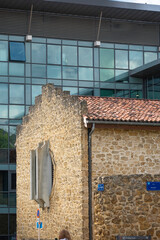 Mont de Marsan showcases a blend of old and new architecture. The historic stone building contrasts with the sleek glass structure, reflecting the area's rich history and modern development.