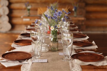 Elegant rustic table setting with flowers and wooden decor for a special event in a cozy cabin