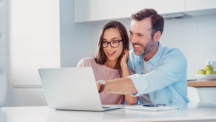 Smiling couple sitting at the computer