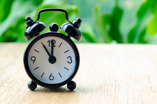 Alarm clock pointing at 11 am with customizable background space for text or ideas.