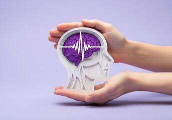 Hands hold brain cutout. Paper head with encephalography on purple background. Alzheimer, autism awareness, stroke, epilepsy, ADHD, seizure disorder, Mental and Neurological Health