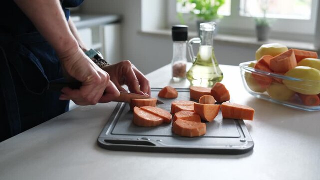 Woman Cutting Raw Sweet Potato In A Close-Up Shot In Home Kitchen