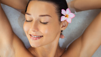 Smiling Woman Relaxing In Spa Bath With Tropical Flower Wellness Concept