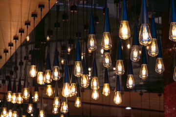 Lots of decorative soft light bulbs hanging from the ceiling in a dark room.