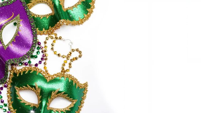 Colorful Mardi Gras masks in green, purple, and gold on white background  are sprkling and shining