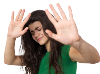 Portrait of a serious young woman showing stop gesture with her palm over white background