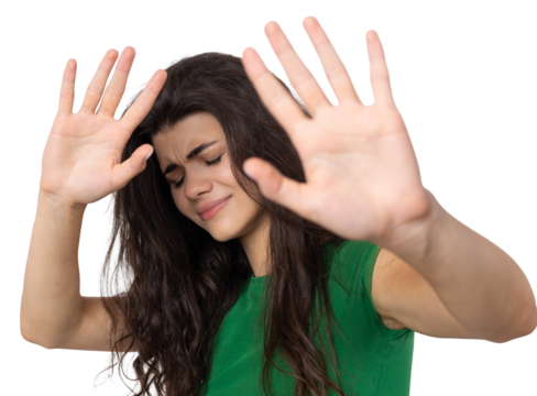 Portrait of a serious young woman showing stop gesture with her palm over white background