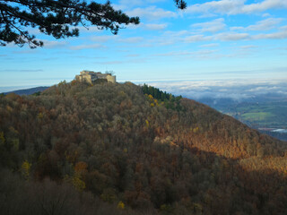 Germany, Foggy colorful autumn view to historical castle ruins hohenneuffen panorama nature landscape view above the swabial jura landscape