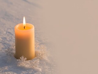 Lit candle glowing warmly in fresh white snow with decorative snowflakes around its base