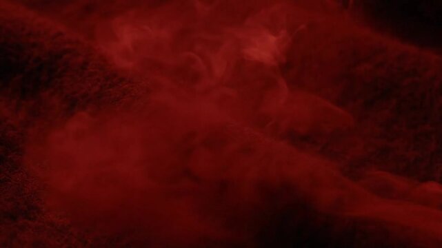 Abstract swirling red smoke and mist creating a dramatic, ethereal atmosphere