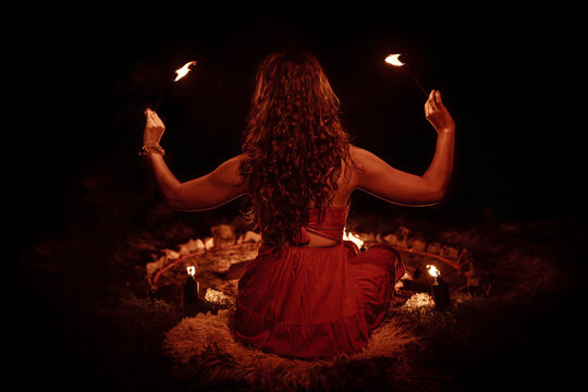 An enchanting fire dancer beautifully showcases her talent with mesmerizing flames during a performance.