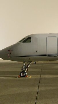 white heavy business jet parked apron fbo gat stands private aircraft emphasized during dark night airport up close panning shot area 
