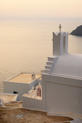 Greek chapel in Potamos village overlooking the sunset over the Aegean Sea. Amorgos, Cyclades, Greece