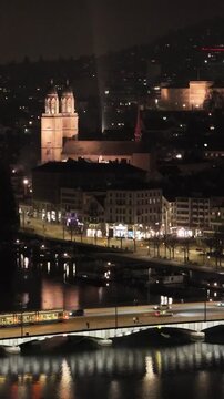 zurich night historic town center trams river bridges churches eth university up close side aerial panning shot view switzerland drone swiss banking charm 