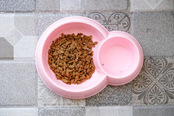 Dry cat food on a pink bowl