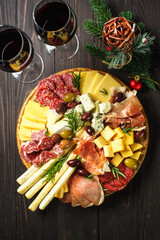 Christmas food Antipasto with red wine. Cheese and meat with olives at serving board. Romantic...